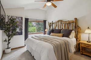 Carpeted bedroom featuring lofted ceiling and ceiling fan