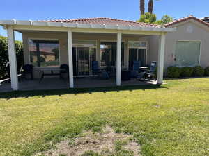 Rear view of house with a patio, stucco siding, a lawn, and a tile roof
