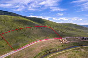 Aerial view of sparsely populated area with property boundaries highlighted and a mountainous background