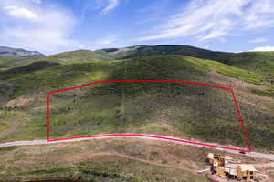 Aerial view of property's location featuring a mountain backdrop and property parcel outlined