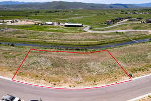Overview of rural landscape with property parcel outlined and a mountainous background