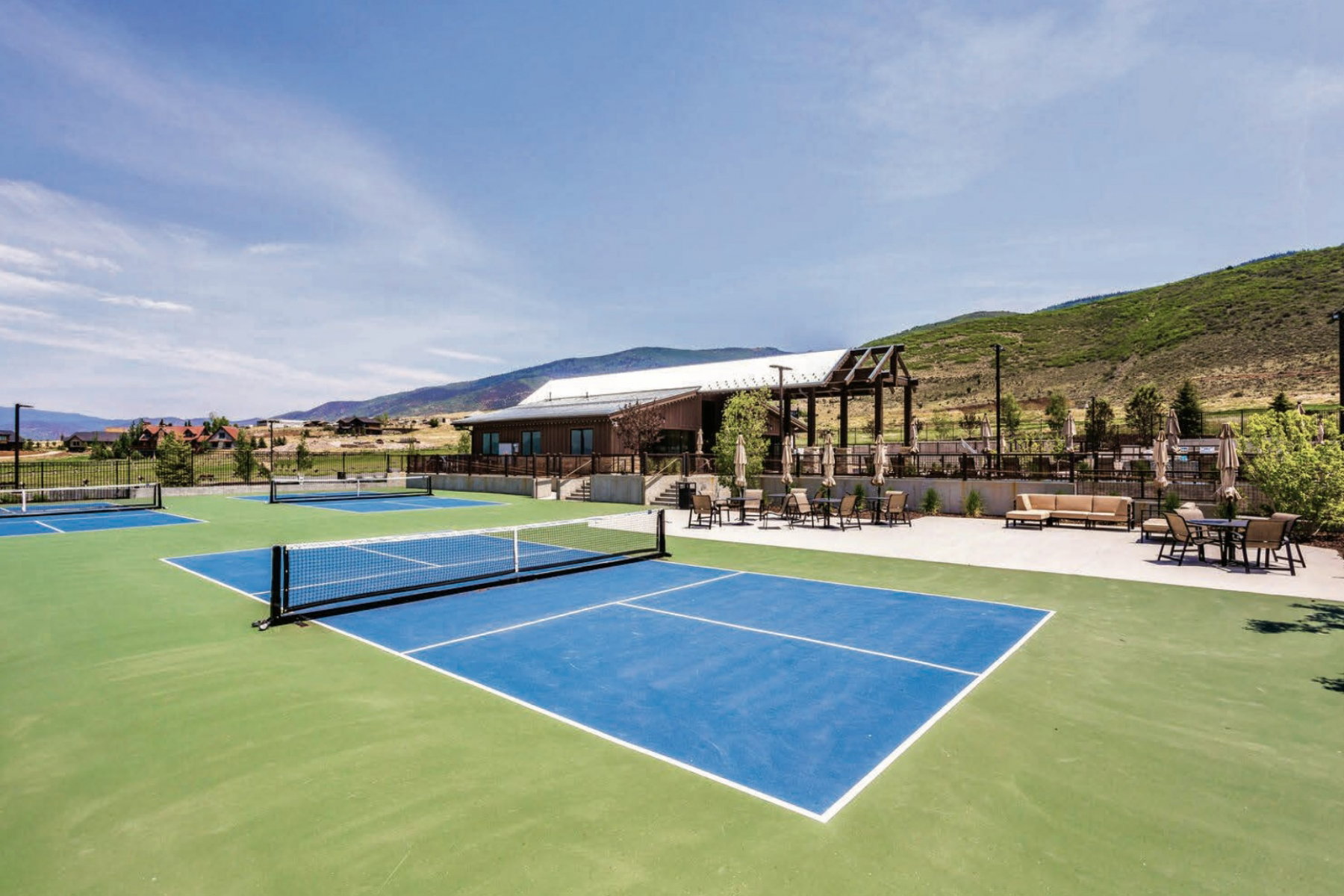View of tennis court featuring a mountain view and outdoor lounge area
