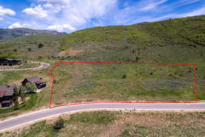 Aerial overview of property's location featuring property boundaries highlighted and a mountain backdrop