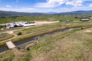 View of mountain backdrop with rural landscape and a large body of water