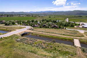 View of mountain background featuring a large body of water and rural landscape