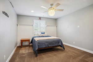 Carpeted bedroom with baseboards and a ceiling fan