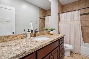 Bathroom with vanity, shower / bath combo, and tile patterned floors