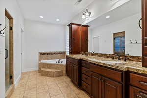 Full bathroom with double vanity, a shower stall, a bath, recessed lighting, and light tile patterned floors
