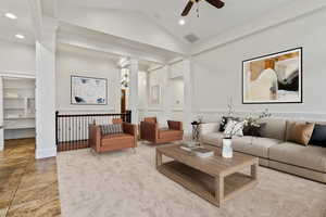 Living room with vaulted ceiling, decorative columns, ceiling fan, and recessed lighting