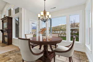 Dining room featuring a chandelier and baseboards