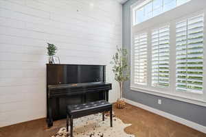 Sitting room featuring carpet flooring and baseboards