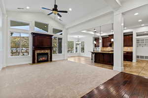 Unfurnished living room featuring light wood-style floors, a chandelier, ceiling fan, a fireplace with flush hearth, and recessed lighting
