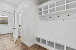 Mudroom with light tile patterned floors and baseboards