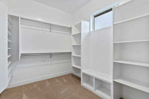 Walk in closet with light carpet