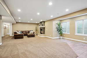 Carpeted living room featuring ornate columns, recessed lighting, a fireplace, and tile patterned floors