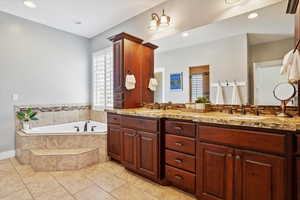 Full bath featuring double vanity, a garden tub, tile patterned flooring, and recessed lighting
