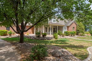 View of front of home featuring a front yard and brick siding