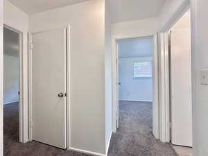 Corridor with carpet and baseboards