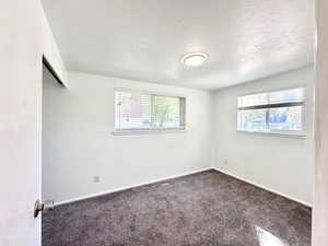 Unfurnished bedroom featuring a closet, carpet floors, and a textured ceiling