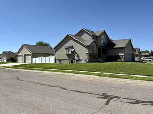 Craftsman-style home with stone siding, stucco siding, driveway, and a detached garage