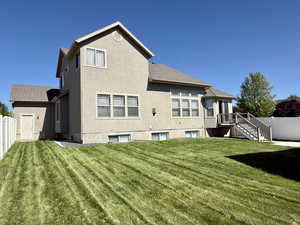 Back of house featuring stucco siding and roof with shingles