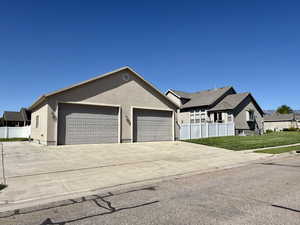 Single story home featuring a garage, driveway, and stucco siding