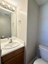 Half bath featuring toilet and vanity
