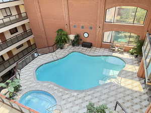 Community pool featuring a hot tub and a patio area