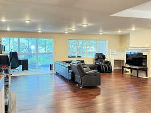 Living area with dark wood-style flooring and a tile fireplace