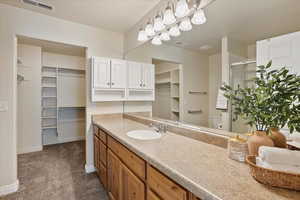 Full bath with vanity, a stall shower, and a walk in closet