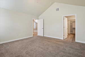 Unfurnished bedroom featuring carpet, a spacious closet, and high vaulted ceiling