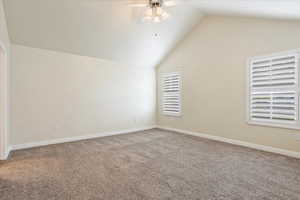 Additional living space featuring ceiling fan, carpet, and lofted ceiling