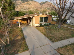 View of front of home featuring a carport, driveway, a mountain view, and brick siding