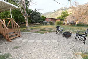 View of yard with an outdoor fire pit and a mountain view