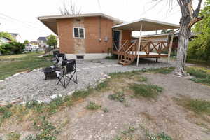 Back of property featuring a fire pit, brick siding, and a deck