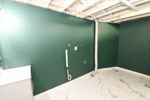 Washroom featuring marble look tiles and baseboards