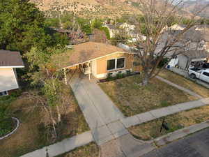 View of front of house featuring an attached carport, driveway, a mountain view, and stucco siding