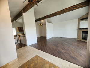 Unfurnished living room featuring tile patterned flooring, a large fireplace, and ceiling fan