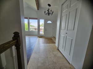 Entrance foyer with a chandelier and baseboards