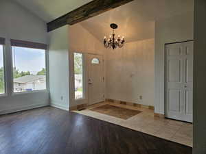 Entryway featuring high vaulted ceiling, a chandelier, hardwood / wood-style floors, and beam ceiling