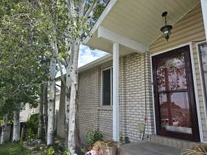 Doorway to property featuring brick siding