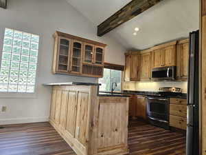 Kitchen featuring appliances with stainless steel finishes, beamed ceiling, dark wood-style floors, dark countertops, and glass insert cabinets