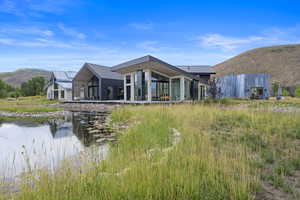 Back of house featuring a mountain view, a patio, and a metal roof