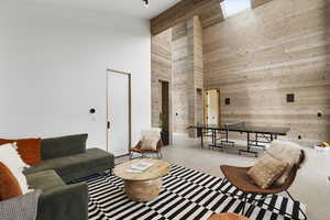 Living area with a towering ceiling and wood walls