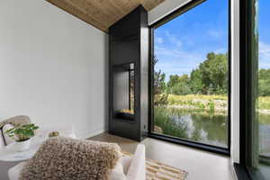 Entryway with a water view, wood ceiling, vaulted ceiling, and concrete floors