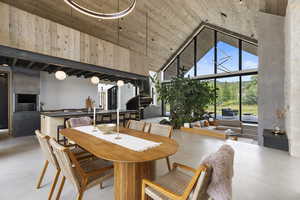 Dining room featuring stairs, concrete flooring, high vaulted ceiling, and wooden ceiling
