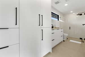Bathroom with vanity, a shower stall, and recessed lighting