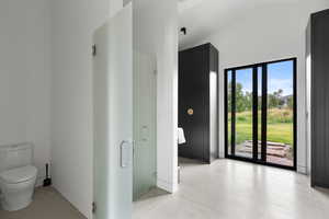 Bathroom featuring lofted ceiling and a shower stall