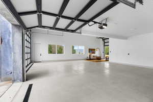 Garage with baseboards and a garage door opener