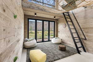 Entryway with wood walls, finished concrete floors, and a towering ceiling